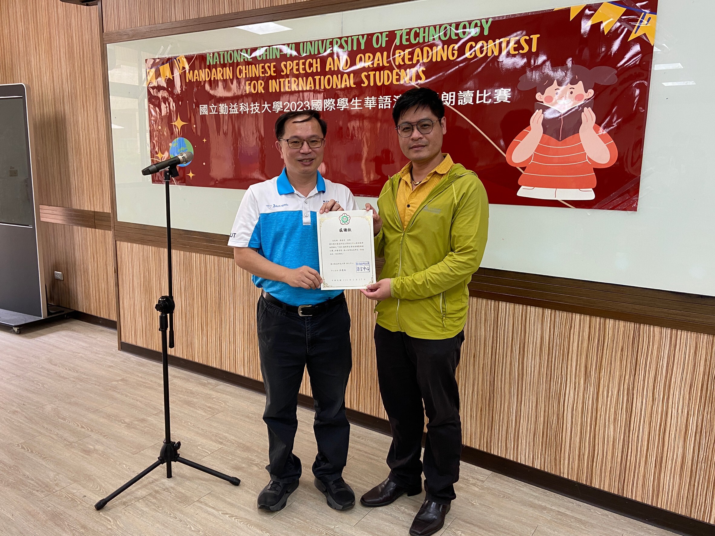 Two people stand together with a cert document on their hand